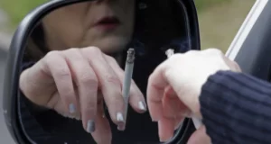Bild på person som röker i bilen